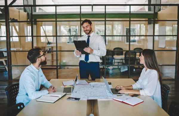 Erfolgreicher Mann Mit Papiermappe Der Neben Dem Desktop Steht Und — Stockfoto