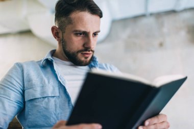 İlginç bir kitap okuyan Kafkas erkek öğrenci ev ödevlerine ve kişisel eğitime boş zaman harcıyor, düşünceli zeki adam edebiyat araştırmalarına yoğunlaşmış veri analiz ediyor.