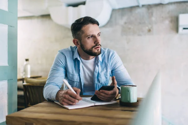 Blogueiro Masculino Pensativo Ponderando Sobre Ideia Publicação Sentado Com Celular — Fotografia de Stock