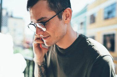 Görme düzeltmesi için gözlüklü genç adamın yan görüntüsü modern cep telefonu, nesil ve iletişim kavramında 4G ile bağlantılı danışmanlık merkeziyle bağlantı kuruyor.