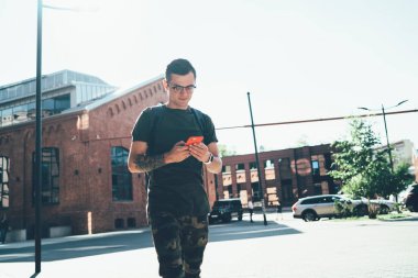 Milenyum erkek yolcusu, elinde cihazla şehir sokaklarını dolaşırken cep telefonu uygulaması üzerinden GPS 'i takip ediyor.