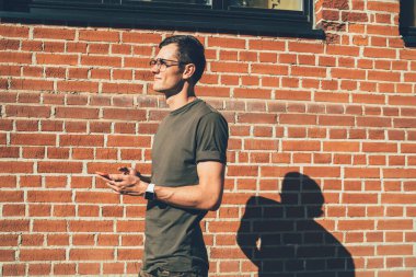 4G internet bağlantısı ve akıllı telefon aygıtı için en iyi operatör tarifesi hakkında düşüncelere dalmış, cep telefonlu düşünceli bir erkek blogcu.