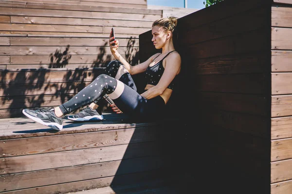 Boční Pohled Vyčerpanou Mladistvou Sportovkyni Chatující Mobilu Při Odpočinku Cvičení — Stock fotografie