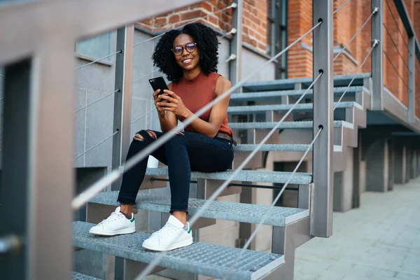 Afroamerykanka Uprzejmie Uśmiechnięta Kobieta Afro Fryzurą Stroju Casual Okularach Pomocą — Zdjęcie stockowe