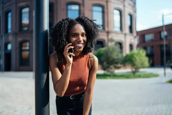 Estudante Afro Americana Feliz Sorrindo Dia Ensolarado Enquanto Conversa Smartphone — Fotografia de Stock