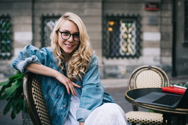 Elegante Mujer Rubia Rizada Gafas Chaqueta Mezclilla Mirando Cámara Con —  Fotos de Stock