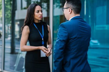 Sakin, siyah elbiseli, yakışıklı İspanyol kadın takım elbiseli adamla iletişim kuruyor ve şehir merkezinde proje zamanı geçirme stratejisini tartışıyor.