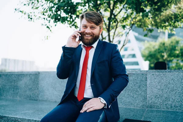 Radostně Usmívající Vousatý Muž Elegantním Obleku Chatuje Mobilním Telefonu Zatímco — Stock fotografie