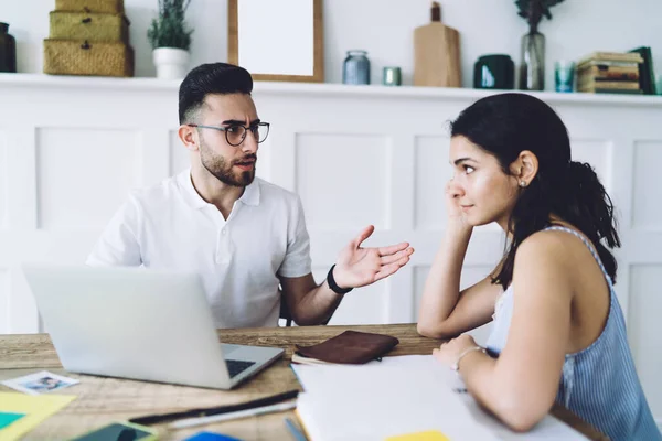 Hombre Insatisfecho Gafas Mirando Mujer Culpable Sentada Mesa Hablando Expresivamente — Foto de Stock