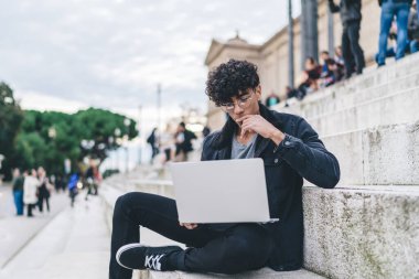 Klasik optik gözlüklü, düşünceli hippi adam İspanyol tarihi merkezinde dinlenirken Barselona rehber bilgisini okurken göz korumasını sağlar. Seyahat incelemesi üzerine kafa yoran düşünceli adam.