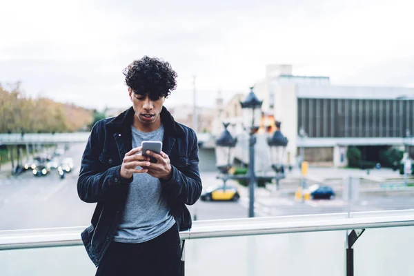 Joven Afroamericano Concentrado Con Ropa Elegante Con Cabello Rizado Usando —  Fotos de Stock