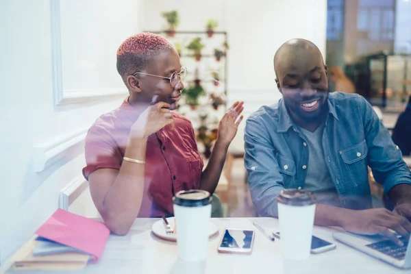 Door Glas Zwart Optimistische Man Typen Laptop Terwijl Vrouwelijke Partner — Stockfoto