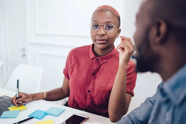 Nachdenkliche Afroamerikanerin Sitzt Schreibtisch Mit Smartphone Neben Männlichem Kollegen Und — Stockfoto