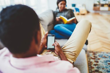 Afrika kökenli Amerikalı bir adamın internet reklamını paylaşmak için fotokopi alanı olan modern cep telefonu cihazını tutarken, dijital akıllı telefon cihazının boş model ekranına seçici bir şekilde odaklandığını gördüm.