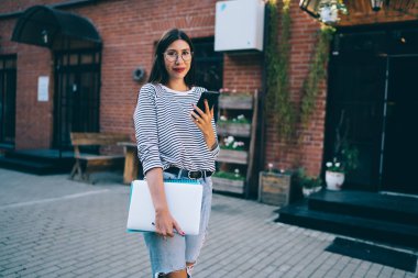 Elinde cep telefonu cihazıyla çekici ve başarılı bir kadının yarım boy portresi ve web sitesinde sanal arkadaşlar ve takipçilerle iletişim kurmanın keyfi, yeni nesil konsepti.