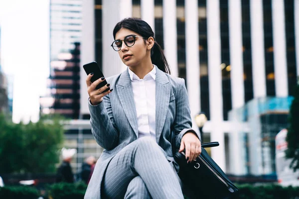 拉丁女商人通过手机阅读网页上的金融新闻 有信心的女首席执行官在城市工作休息期间使用手机搜索联系方式或数据信息 — 图库照片