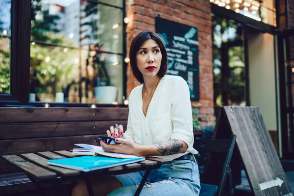 Pensive Hipster Girl Sitting Street Cafeteria Spending Time Planning Coursework — стоковое фото