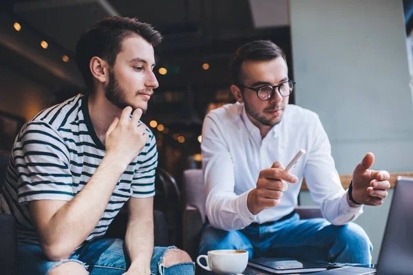 Mladí Muži Neformálních Oblečení Přemýšlet Diskutovat Informace Moderního Notebooku Zatímco — Stock fotografie