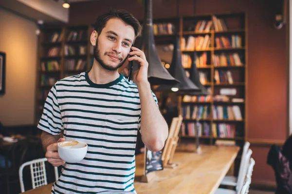 Ung Man Randig Shirt Håller Kopp Kaffe Och Tittar Bort — Stockfoto