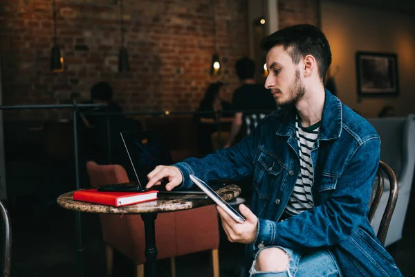 재킷을 프리랜서 남성의 노트북을 테이블에 앉아서 카페에서 태블릿 컴퓨터를 일하는 — 스톡 사진