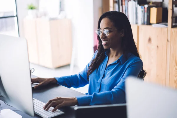 Skrattar Afroamerikansk Kvinna Glasögon Sitter Vid Bordet Tittar Stora Datorskärm — Stockfoto