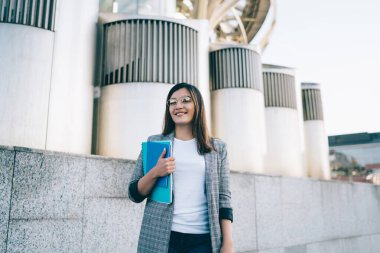 Şık giyinmiş ve gözlüklü bayan öğrencilerin yarım boy portresi şehrin mimarisi ile kare üzerinde duran kitaplarla, güzel beyaz hippi kız şehri gezmekten zevk alıyor.