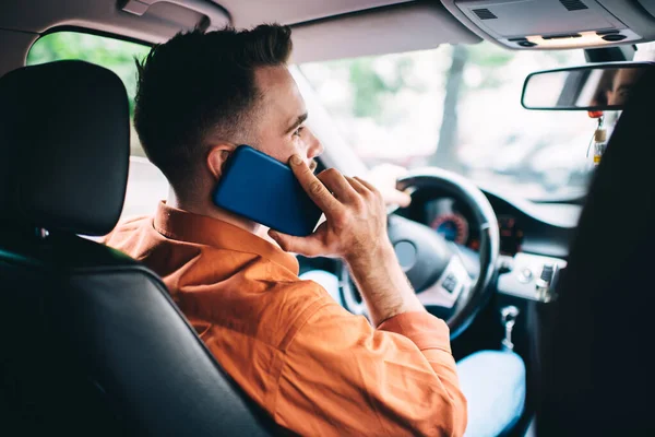 Modern giysili, modern araba kullanan ve arka planda bulanık bir akıllı telefondan konuşan modern yakışıklı bir adamın arka planı.