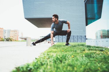 İz sürme kıyafetleri içinde kendine güvenen bir erkek sabah egzersizi sırasında kulaklıkla müzik dinleyen kaslı, kaslı, kaslı ve kaslı bir sporcunun vücut ısısına yoğunlaşmıştı.