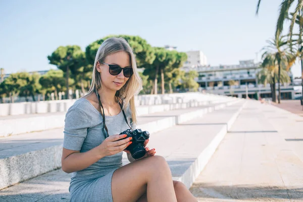 Mulher Loura Feliz Óculos Sol Verificando Fotos Câmera Moderna Enquanto — Fotografia de Stock