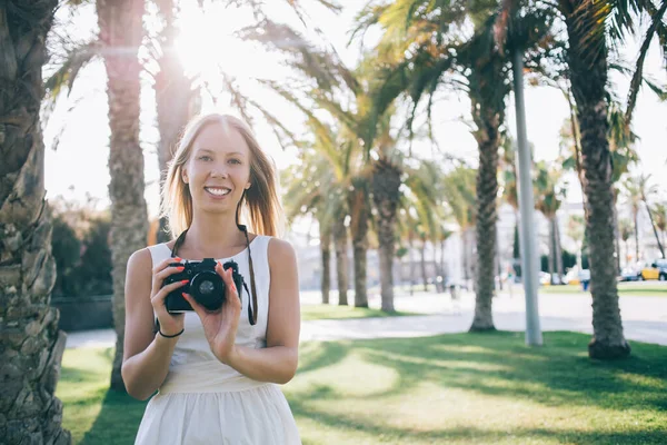 Joven Viajera Positiva Vestido Blanco Sosteniendo Cámara Fotográfica Mientras Está — Foto de Stock