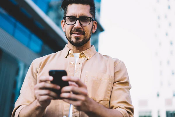 Alegre Millennial Masculino Usando Telefone Celular Para Navegar Redes Sociais — Fotografia de Stock