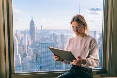 Modern dokunmatik pedlere uygulanan videoları izlemesi için göz koruması sağlayan optik gözlüklü bin yıllık blog yazarı, dijital tabletli Kafkasyalı hippi kız 4G internet kullanıyor.