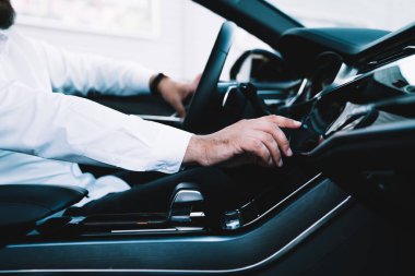 Çağdaş arabada otomotiv direksiyonu kullanırken çok kullanılan sistem, konum belirleme teknolojisini kontrol eden adam kokpitteki GPS 'leri takip etmek için gösterge paneline dokunuyor
