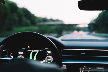 Otomotiv paneline seçici bir şekilde odaklanın. Seyahat noktasına gitmek için navigasyon bilgileriyle birlikte teknoloji ekranı, erkek sürücü iot sistemli pahalı kiralık arabayla üstgeçit yolundan geçiyor.