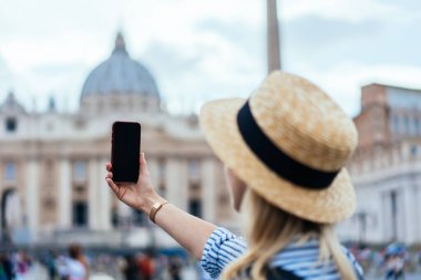 Roma 'da yaz tatillerinde heyecanlı turun tadını çıkarırken şapkalı hippi kadın gezginin akıllı telefonuyla selfie çekişini.