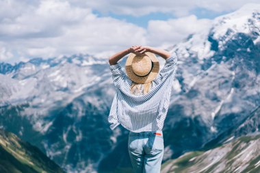 Bulutlu bir günde Lago di Braies 'e seyahat ederken şapkanın arkasında el ele tutuşan ve sıradağlara hayran olan anonim bir kadın. 