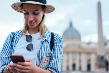 Gülümseyen hippi kız Vatikan 'ı ziyaret ettikten sonra kafeleri aramak için akıllı telefon kullanıyor. Arkadaşlarıyla sohbet eden güzel bayan turist İtalya' da tek başına cep telefonuyla tatil yaparken mesaj atıyor.