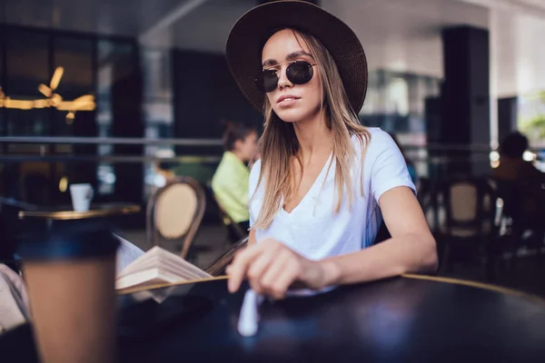 Привлекательная Длинноволосая Женщина Шляпе Солнцезащитных Очках Сидящая Кафе Читающая Книгу — стоковое фото