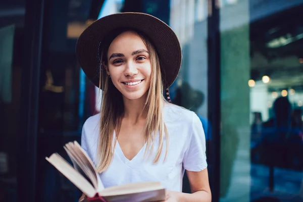 Glückliche Frau Mit Hut Lässiger Kleidung Liest Buch Während Sie — Stockfoto