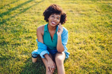 Çekici esmer tenli hippi kızın portresi cep telefonuyla konuşan Afro-Amerikan milenyum kadını güneşli bir günde cep telefonuyla arıyor.