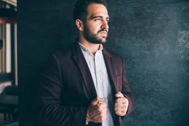 Resmi olarak karizmatik, idareci, genç ve etnik bir erkeğin yakın çekimi hayranlık uyandıran şık bir takım elbise giyerek iş yerinde dikilip gözlerini kaçırıyor.