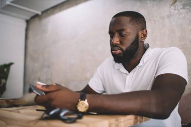 İnternet bankacılığı ve metin iletişimi için cep telefonu uygulaması kullanan Afrikalı Amerikalı sakallı öğrenci, sosyal ağ ağı kurmak için 4G 'ye bağlanan 20li yaşlardaki hippi çocuk.