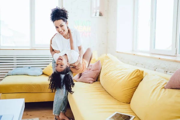 Šťastný Smích Afroameričanka Nošení Okouzlující Dcera Rukou Baví Společně Doma — Stock fotografie