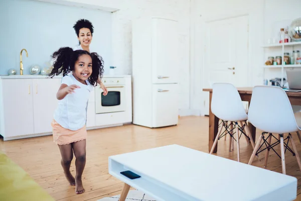 Radostná Afroameričanka Kudrnatými Vlasy Pobíhající Obývacím Pokoji Moderního Bytu Vedoucí — Stock fotografie