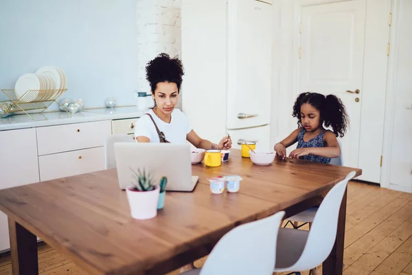 Obsazeno Afroameričanka Matka Bílé Košili Sedí Stolu Prohlížení Notebook Zatímco — Stock fotografie