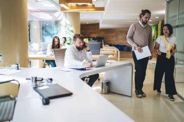 Kafkasyalı bir adam bilgisayardan internet bilgilerini tartışmak için meslektaşını ararken, iş projesinin yakınından geçen başarılı erkek ve kadın meslektaşları iş projeleri hakkında iletişim kuruyor.