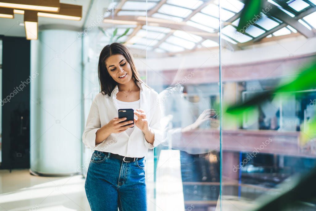 Cheerful millennial woman checking funny received email messages via cellphone device connecting to 4g wireless, carefree female phoning with technology during cell texting on public social website