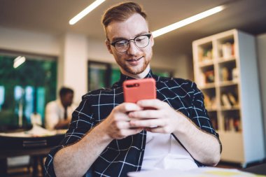 Modern dijital akıllı telefondaki 4G ile sosyal ağlarda web içeriğini okumak ve mesajlaşmak için göz koruması sağlayan optik spekülasyonlar yapan beyaz çağdan kalma hippi bir adam.