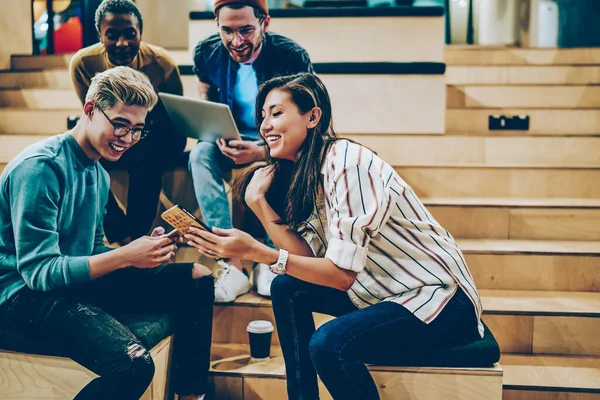 幸せな男性と女性の10代の学生は 大学での会議中にスマートフォンを介してオンラインでマルチメディアファイルを共有し 一緒に研究のための技術を使用して従業員の熟練した積極的な多人種の乗組員 — ストック写真