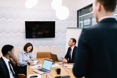 Zeki, konsantre, yaratıcı, çoklu etnik çeşitlilikte iş ortaklığı sırasında liderin düşüncelerini sunarken yeni bir başlangıç hakkında düşünen çok ırklı meslektaşlar.